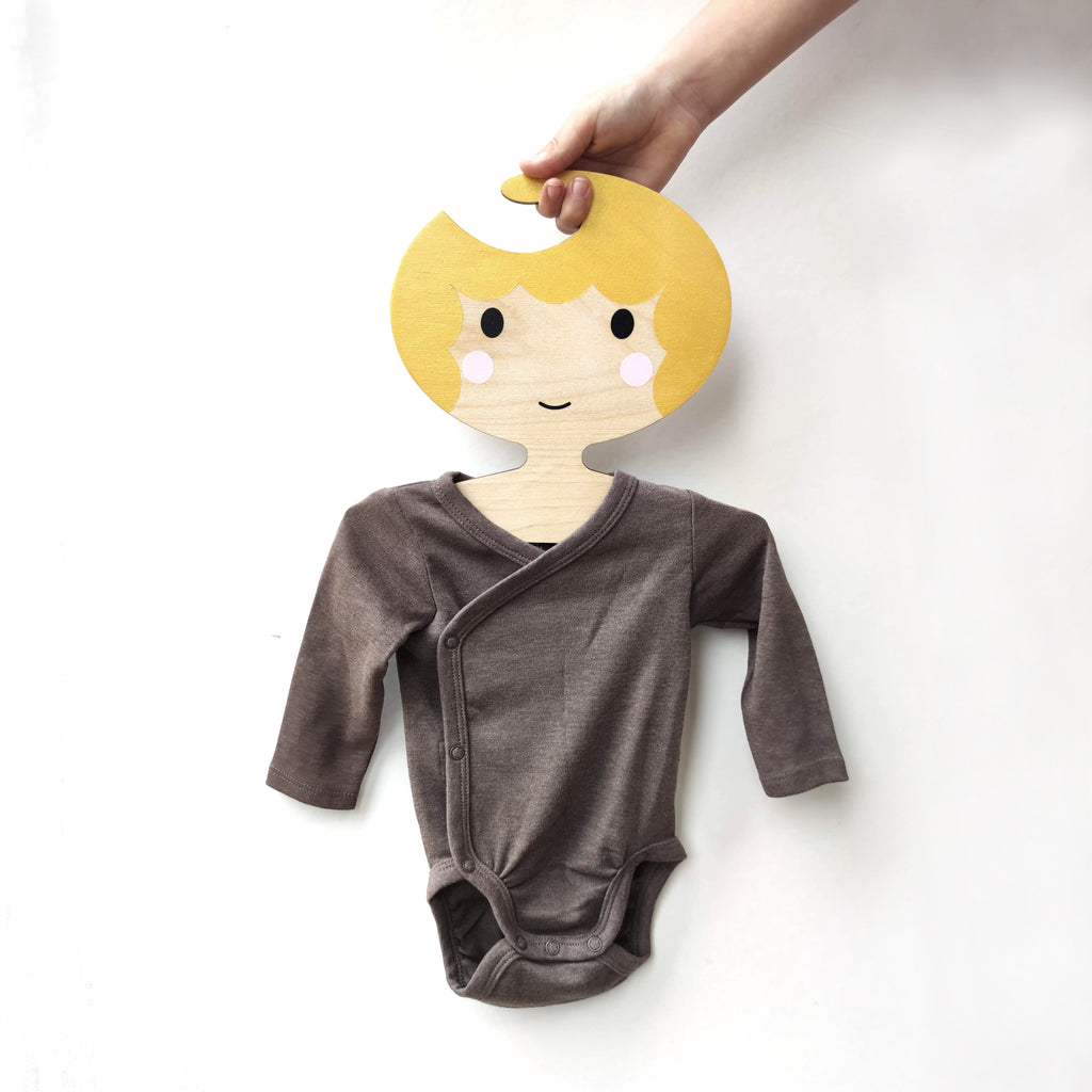 childs wooden clothes hanger designed in the shape of a face. girl with golden hair. cool clothes hanger by Red Hand Gang